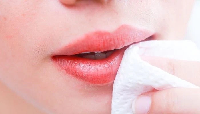 Ilustrasi mengapus lipstik yang menempel di bibir.