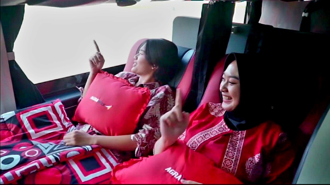 Penumpang sleeper bus Agra Mas sedang menikmati perjalanan sambil rebahan.