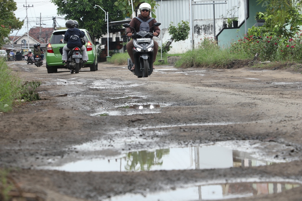 LUBANG BERSERAK: Kondisi Jalan Raya Ngebel persisnya timur Pasar Janti, akses menuju Telaga Ngebel via Madiun rusak parah.