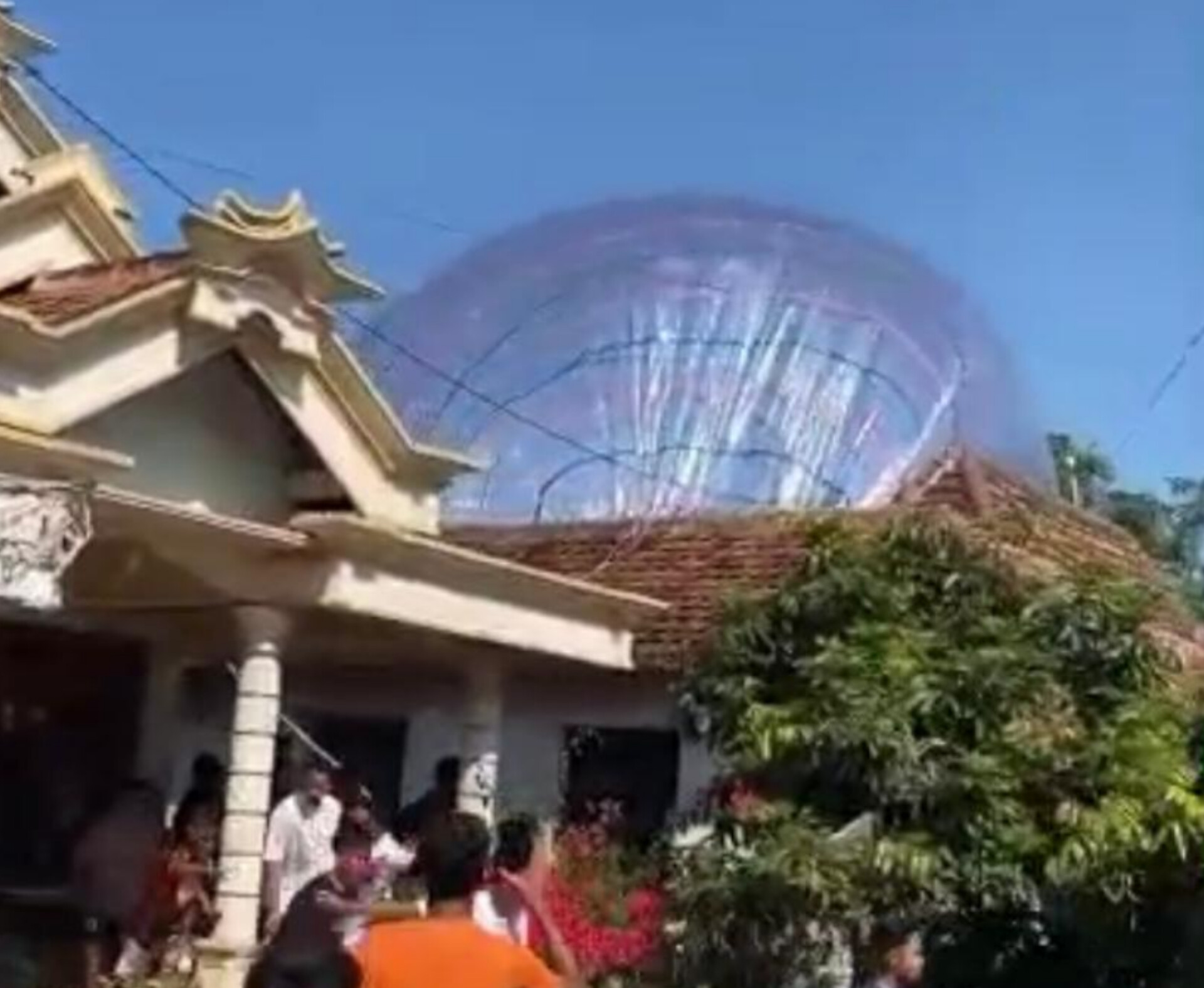 Puluhan warga menyerbu rumah Suratun di Dusun Balungasri, Kebonsari, setelah balon udara super jumbo jatuh dan menimpa atap. FOTO: TANGKAPAN LAYAR