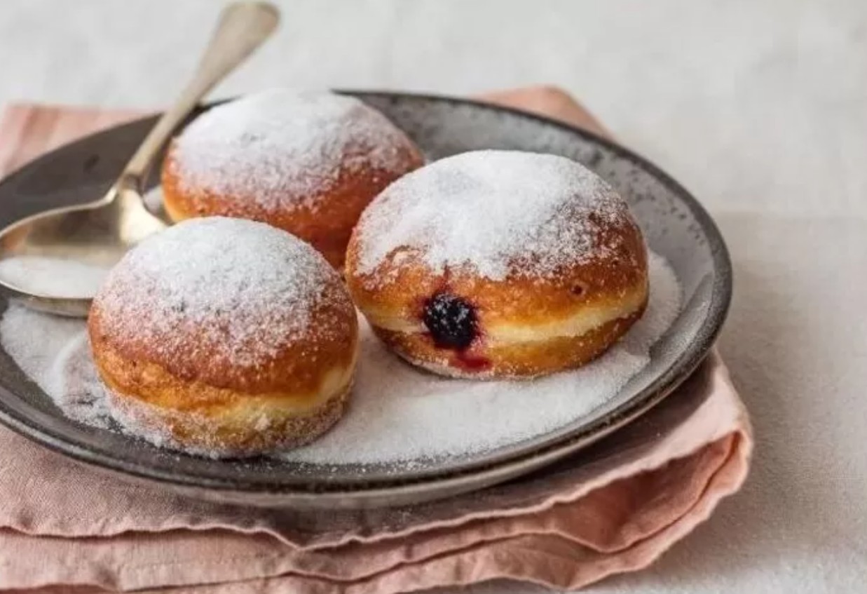 Ilustrasi donat bomboloni dengan topping gula halus.