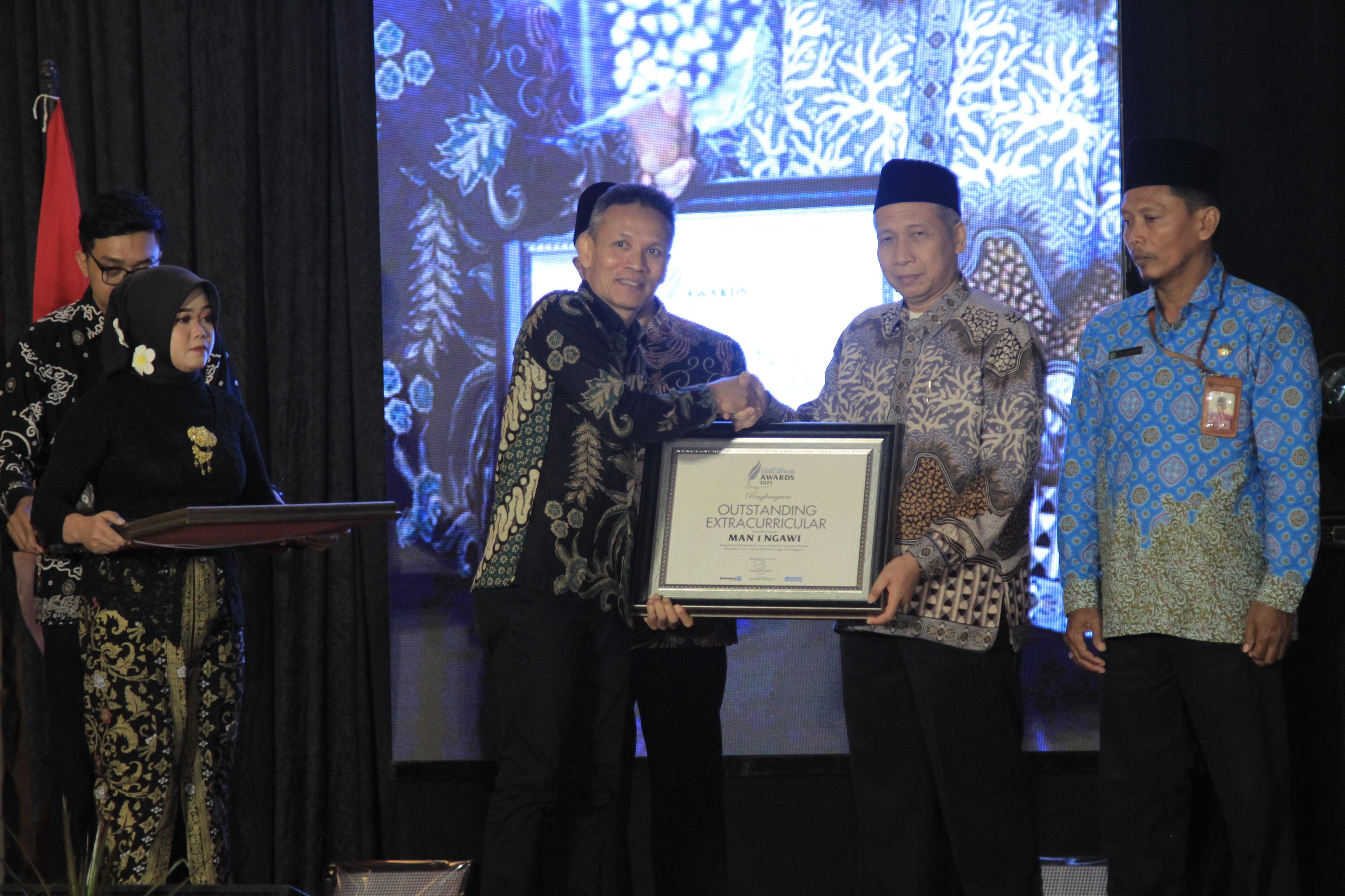 Kepala MAN 1 Ngawi Maskur menerima penghargaan Radar Madiun Education Awards kategori Outstanding Extracurricular.