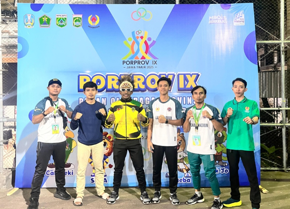 Simson Wandik bersama ofisial dan perwakilan KONI Kabupaten Madiun menunjukkan medali emas kick boxing. Foto: Muchtar Ruzi for Radar Caruban
