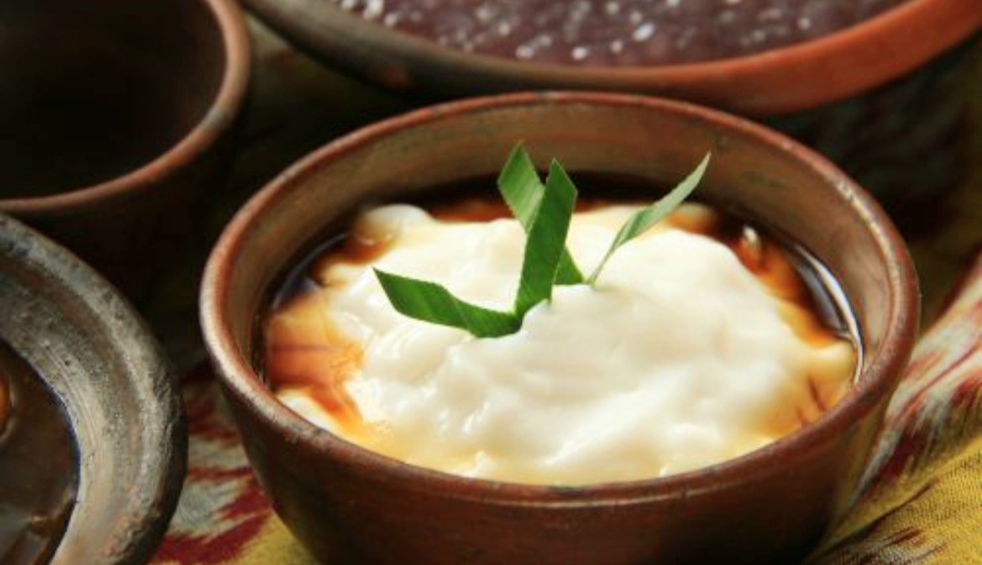 Bubur sumsum lembut dan gurih, disajikan dengan kuah kinca manis.