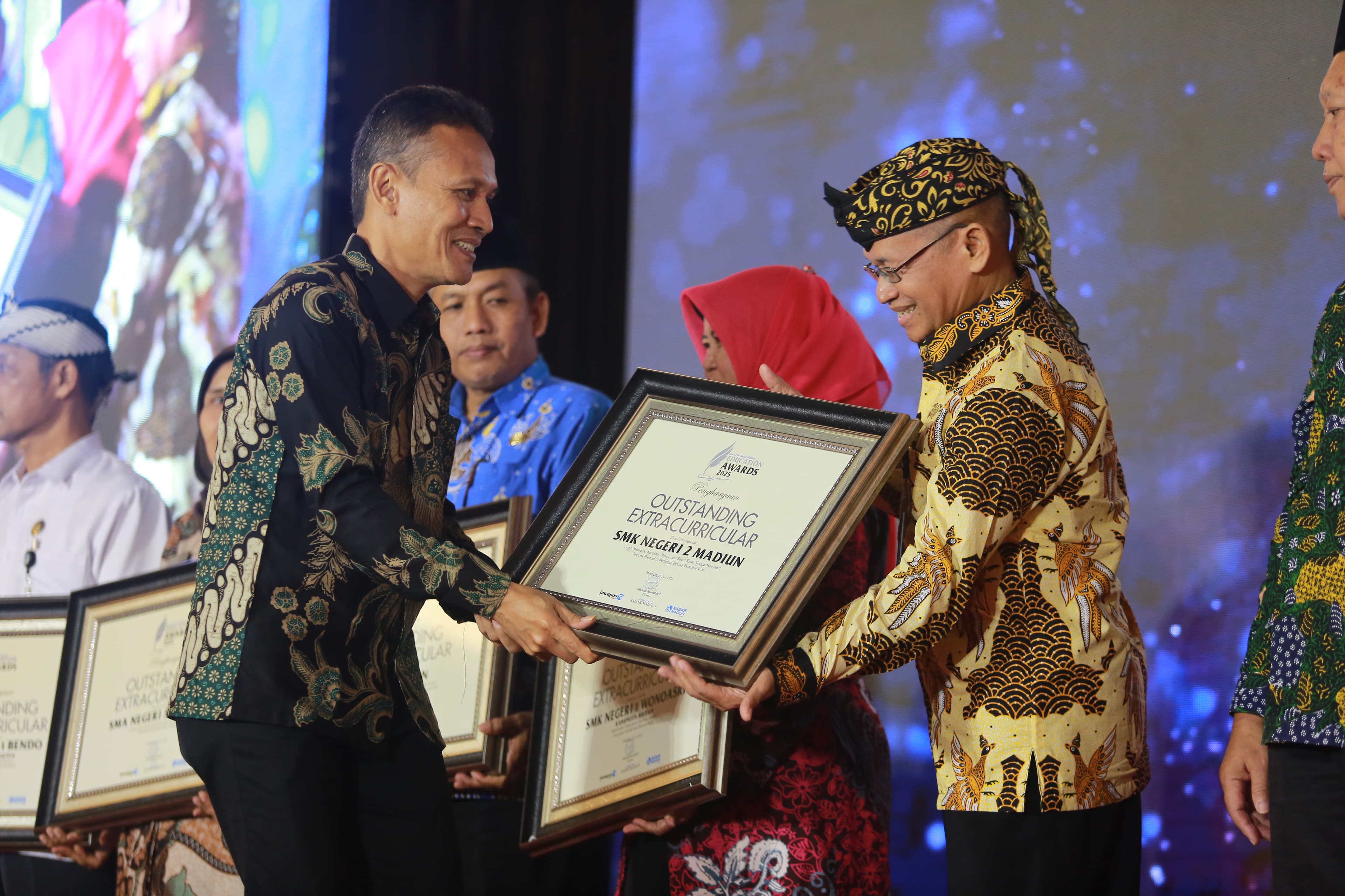 BANGGA: Puji Rahayu, Kepala SMKN 2 Madiun, menerima penghargaan Outstanding Extracurricular di ajang Jawa Pos Radar Madiun Education Awards 2025.