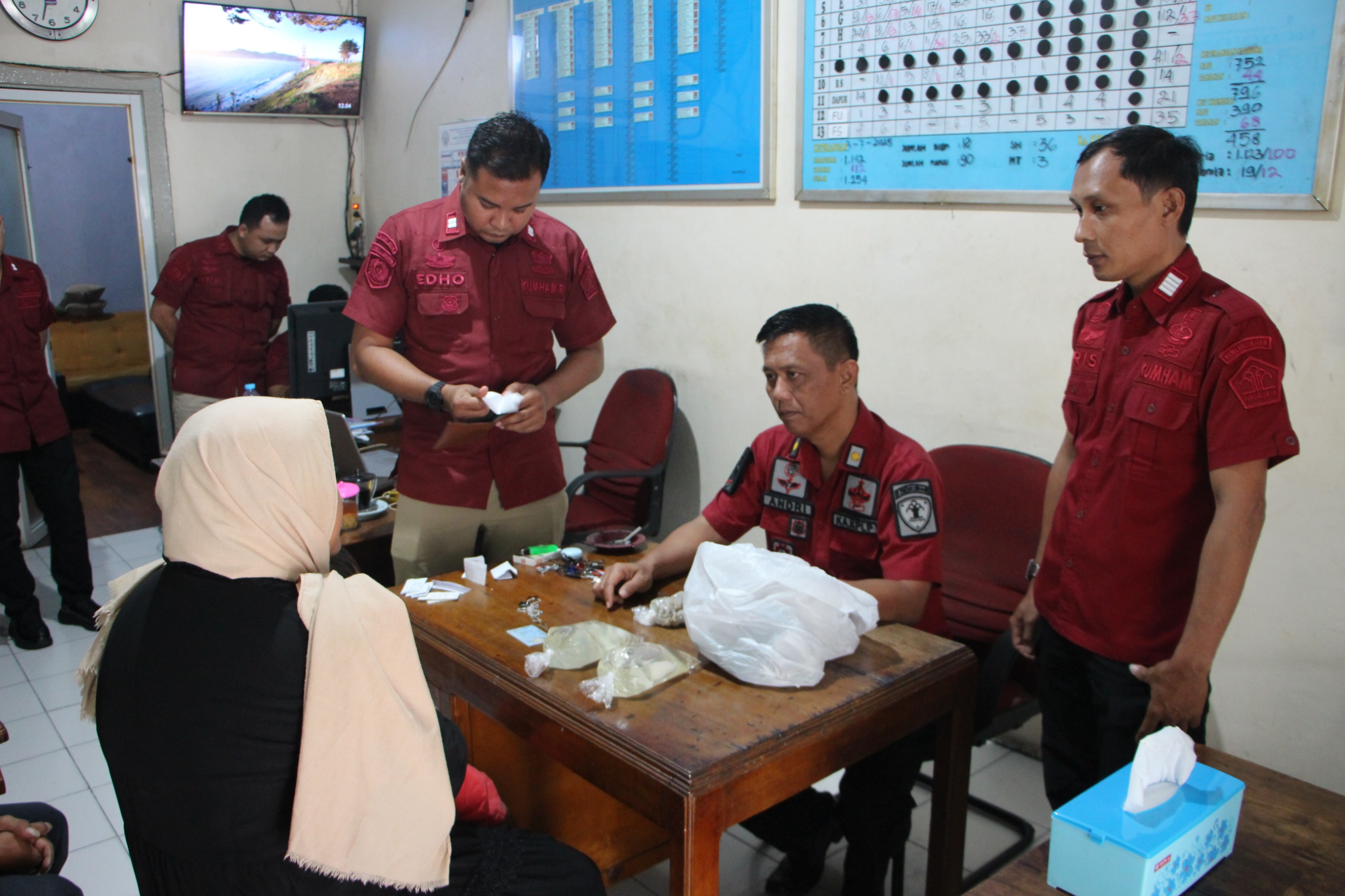 Petugas Lapas Kelas I Madiun memeriksa pengunjung yang kedapatan membawa miras untuk anaknya yang ditahan, Kamis (3/7). FOTO: LAPAS KELAS I MADIUN