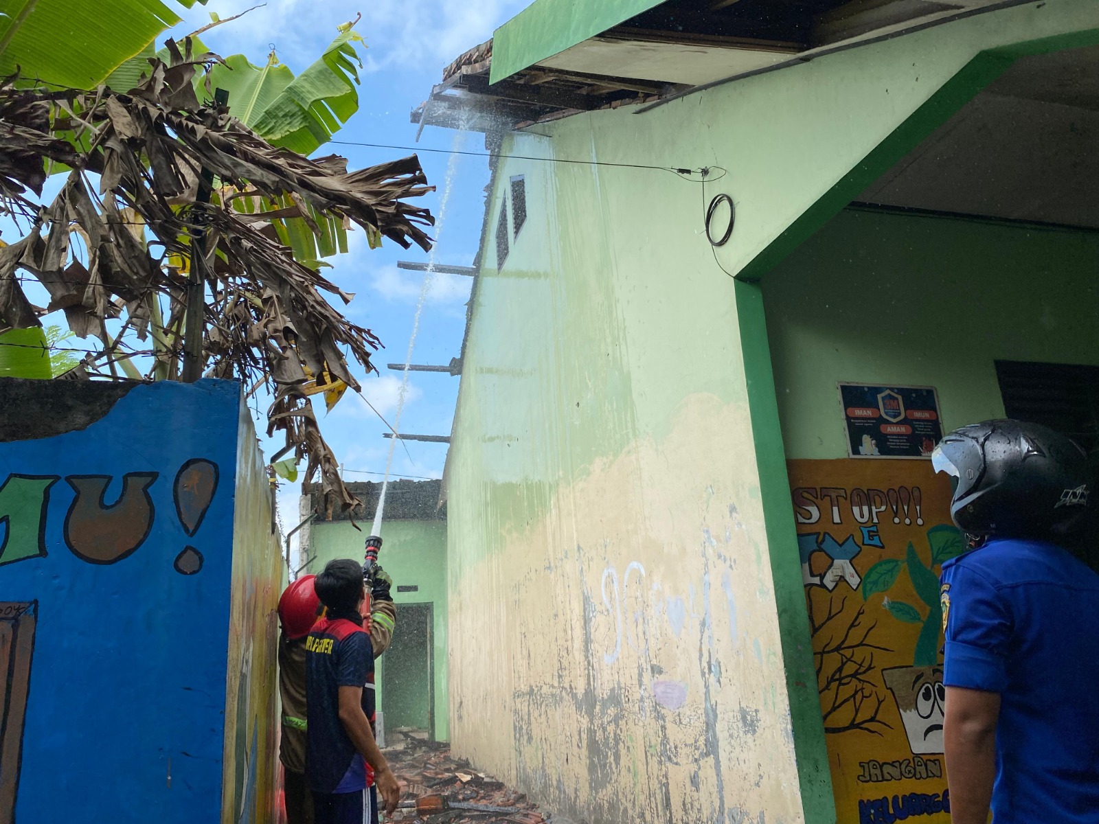 Petugas Damkar Kabupaten Madiun saat menangani kebakaran atap ruang kelas di salah satu sekolah di Jiwan. FOTO: DIAN RAHAYU/RADAR CARUBAN