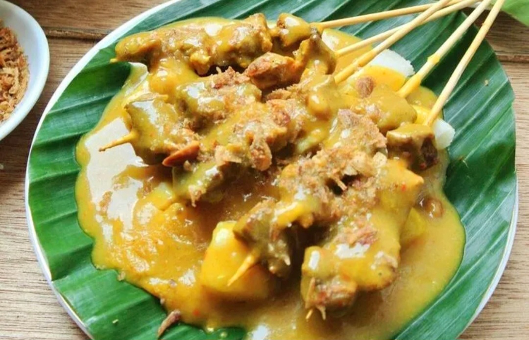 Sate Padang saus kuning kental dan bumbu khas Minang.