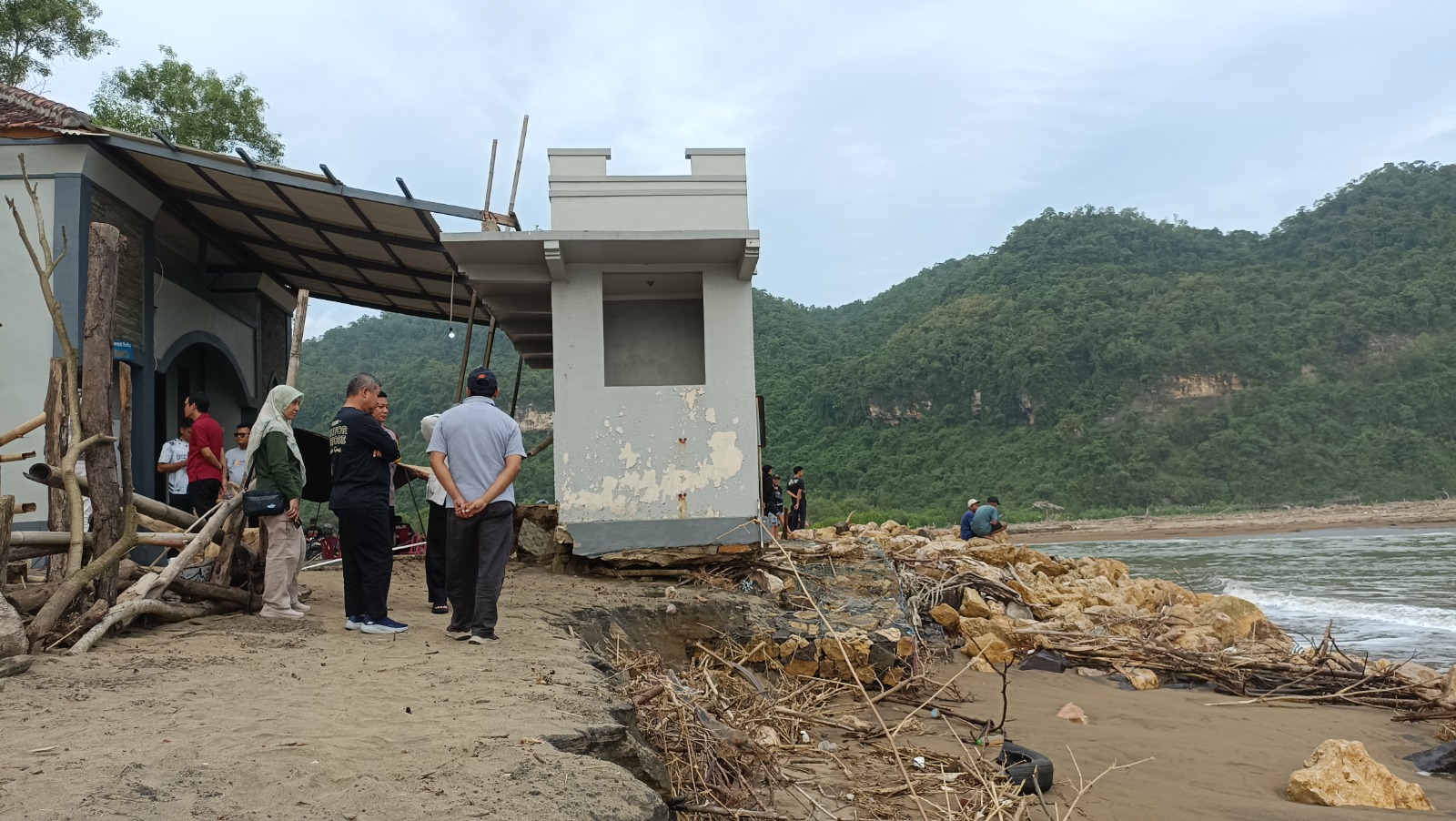 Sekda Heru Wiwoho, Kepala DPUPR Suparlan dan Kepala Disparbudpora Turmudi meninjau dampak kerusakan dari abrasi di kawasan Pantai Pancer Door, kemarin (9/7). NUR CAHYONO/RADAR PACITAN