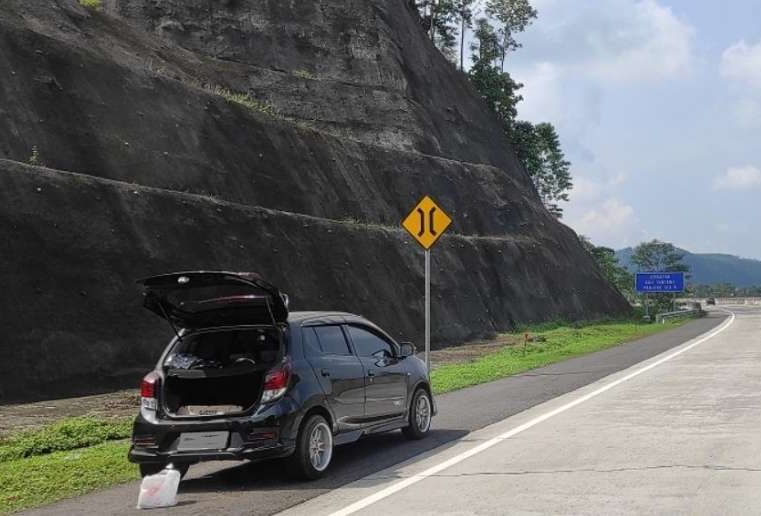 Ilustrasi mobil berhenti di bahu jalan tol.