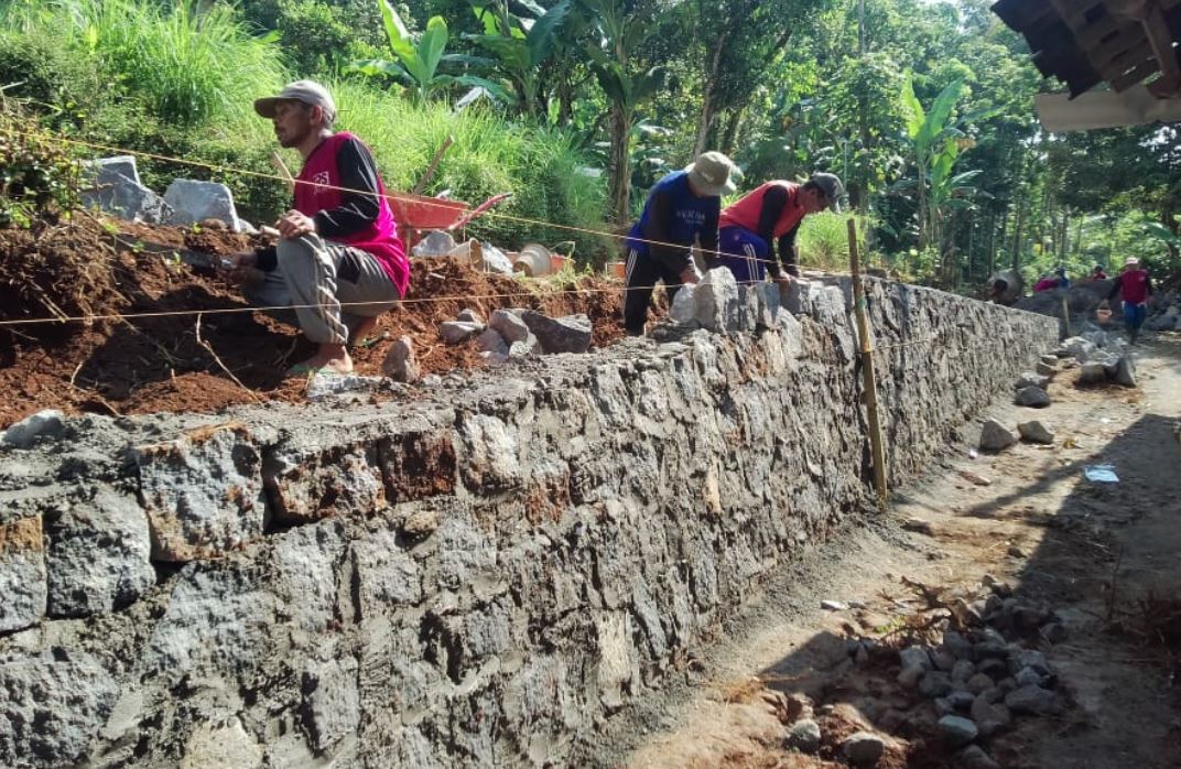 BANGUN TPT: Pembangunam Talud Penahan Tanah (TPT) di Dusun Nglencer, RT 04 RW 03 untuk mencegah jalan longsor dan terkikis aliran air saat hujan.