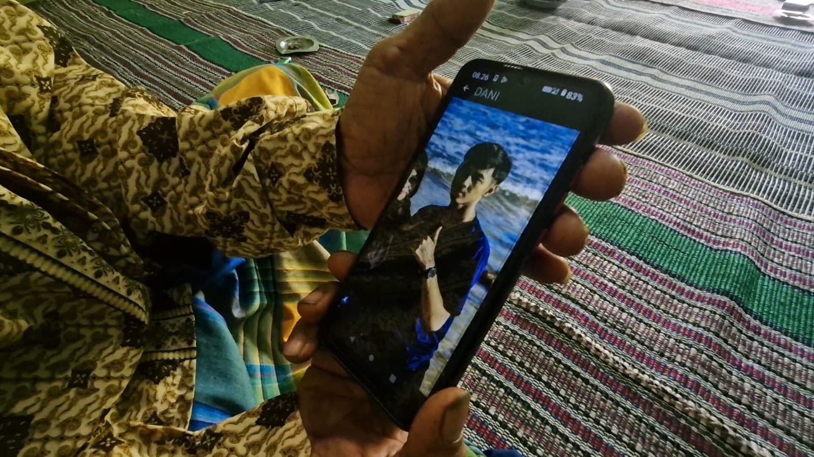 Siman menunjukan foto cucunya, Sakti Ramadhani yang meninggal dunia di Jepang usai terlibat kecelakaan kerja. FOTO: SUGENG DWI N./JAWA POS RADAR PONOROGO