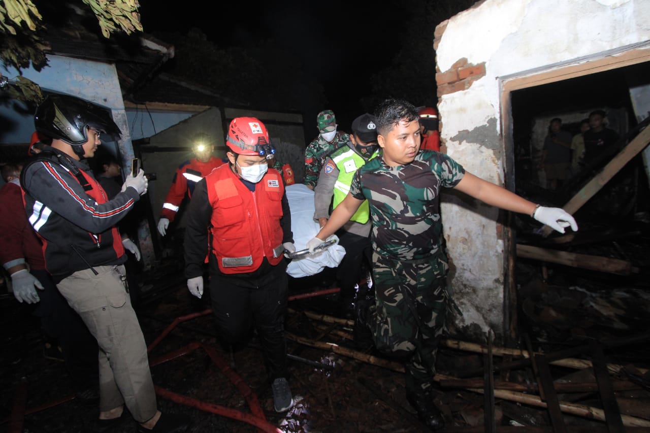 Petugas mengevakuasi jasad seorang lansia yang tewas terbakar saat rumahnya di Maospati, Magetan, dilalap api pada Senin (21/7) malam. FOTO: AJI PUTRA/RADAR MAGETAN