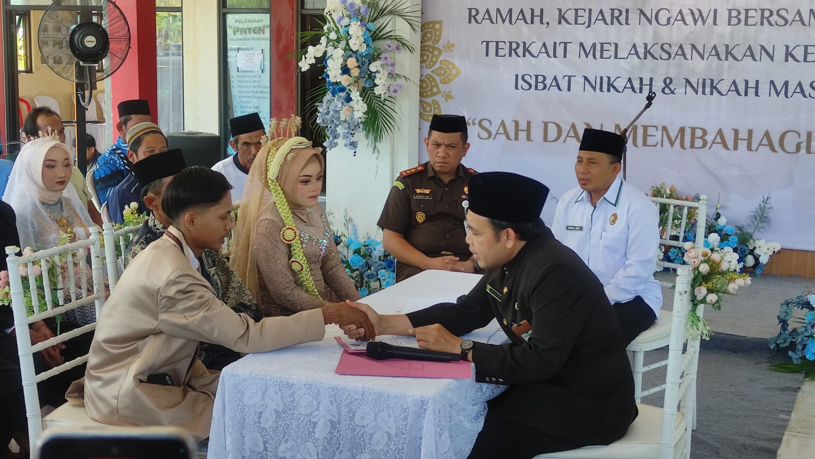 SAKSI NIKAH: Kajari Ngawi Susanto Gani bersama Ketua Baznas Ngawi Samsul Hadi menjadi saksi nikah dalam kegiatan isbat dan nikah masal yang dilaksanakan di Pendapa Kecamatan Walikukun, Selasa (22/7).