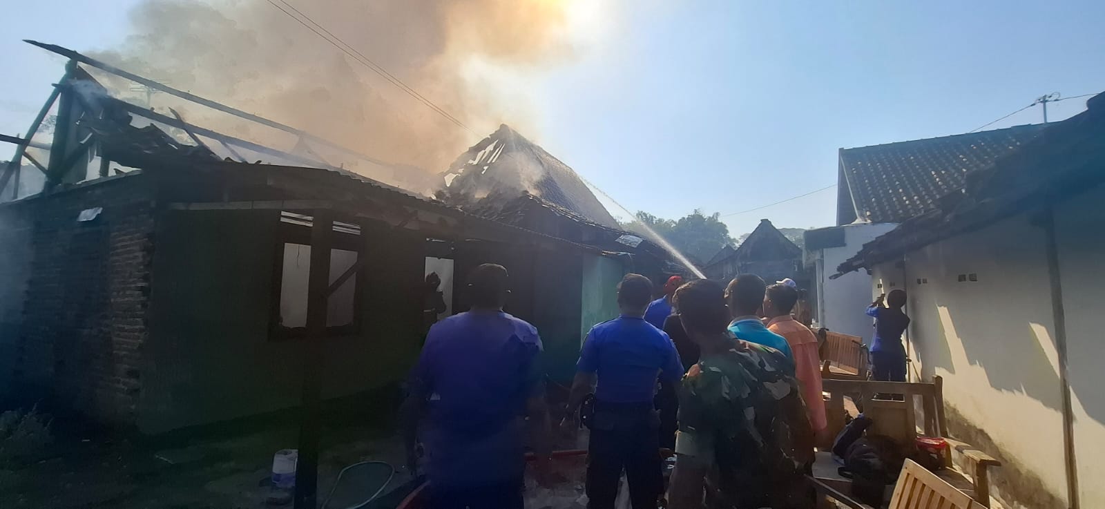 Petugas damkar saat memadamkan api yang membakar dua rumah warga di Desa Ngawi Purba, Kamis (24/7) pagi. FOTO: ASEP SYAEFUL/RADAR NGAWI