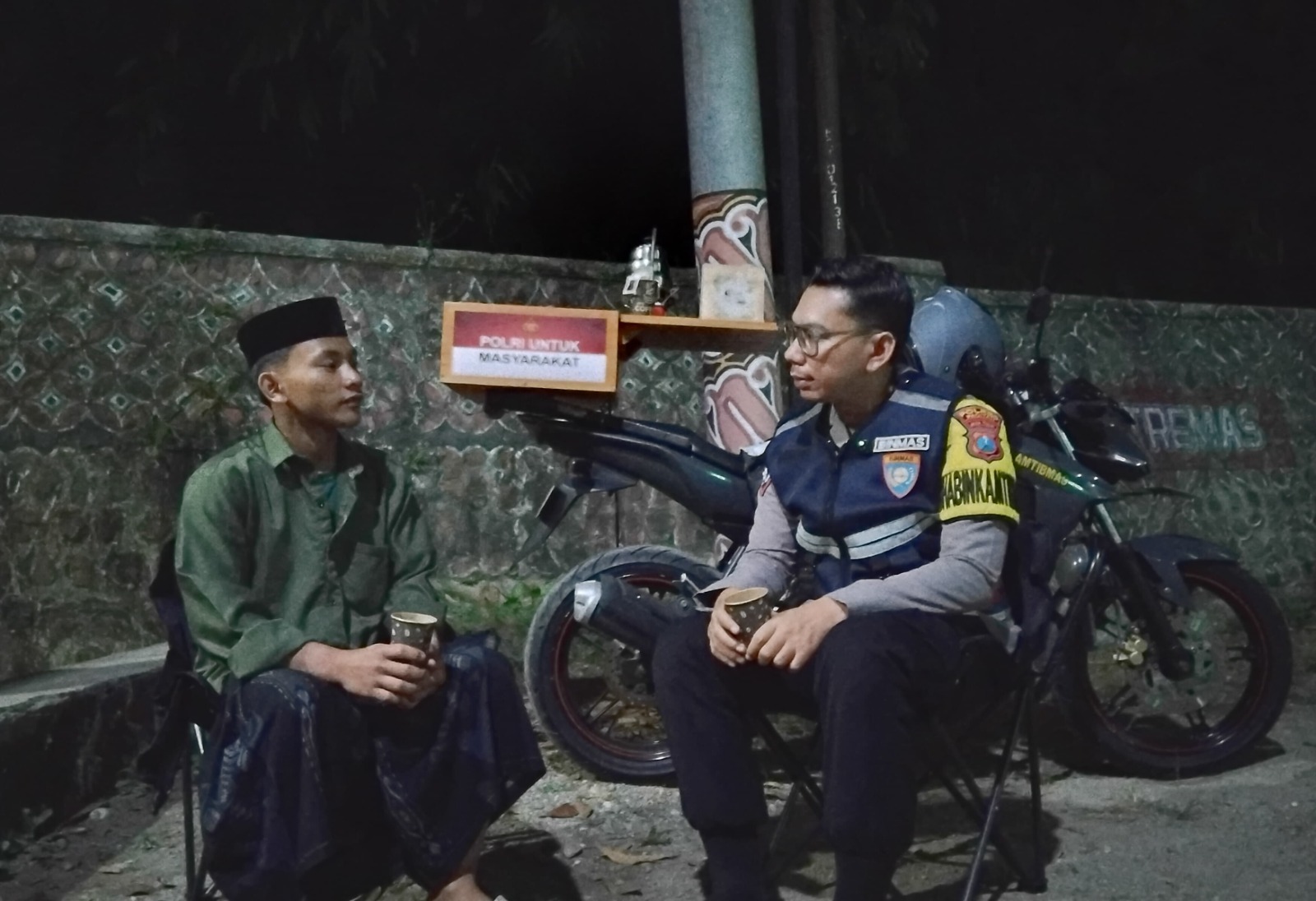 Brigpol Didin saat menyapa warga di Desa Arjosari sambil menyeduh kopi dari motor dinas yang dimodifikasi.