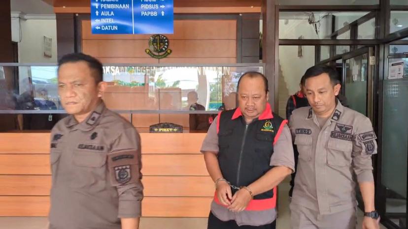 Dua tersangka digelandang ke mobil tahanan usai ditetapkan Kejari Kabupaten Madiun terkait kasus korupsi kolam renang di Desa Sukosari, Dagangan, Kamis (24/7) lalu. ISTIMEWA/JAWA POS RADAR MADIUN