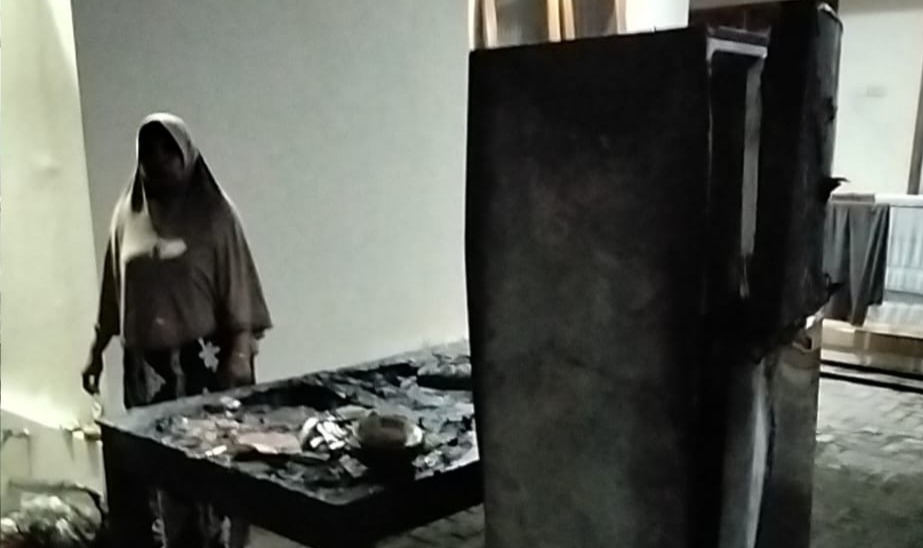 Petugas damkar menyemprot sisa api di rumah Nur Efendi yang terbakar akibat korsleting di Ngariboyo, Magetan. FOTO: ISTIMEWA