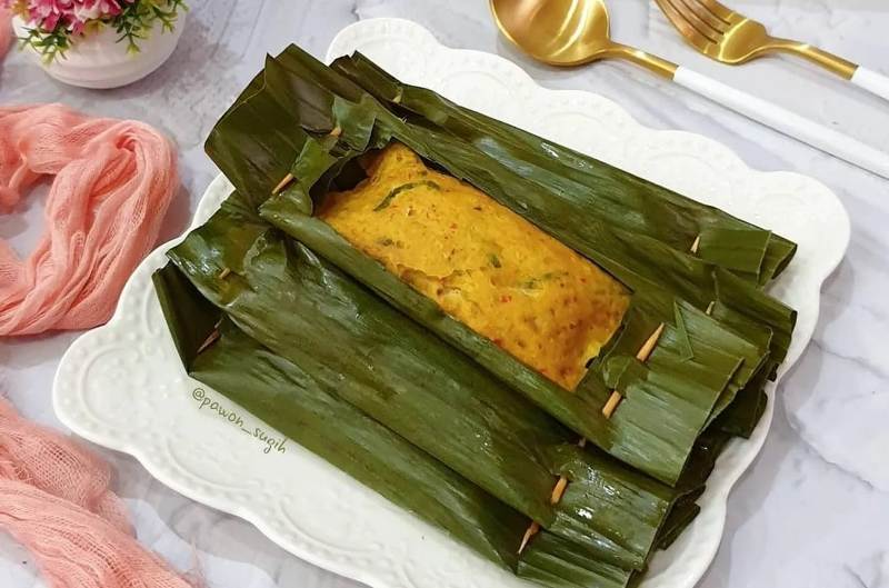 Ilustrasi pepes ayam giling yang harum dibungkus daun pisang.