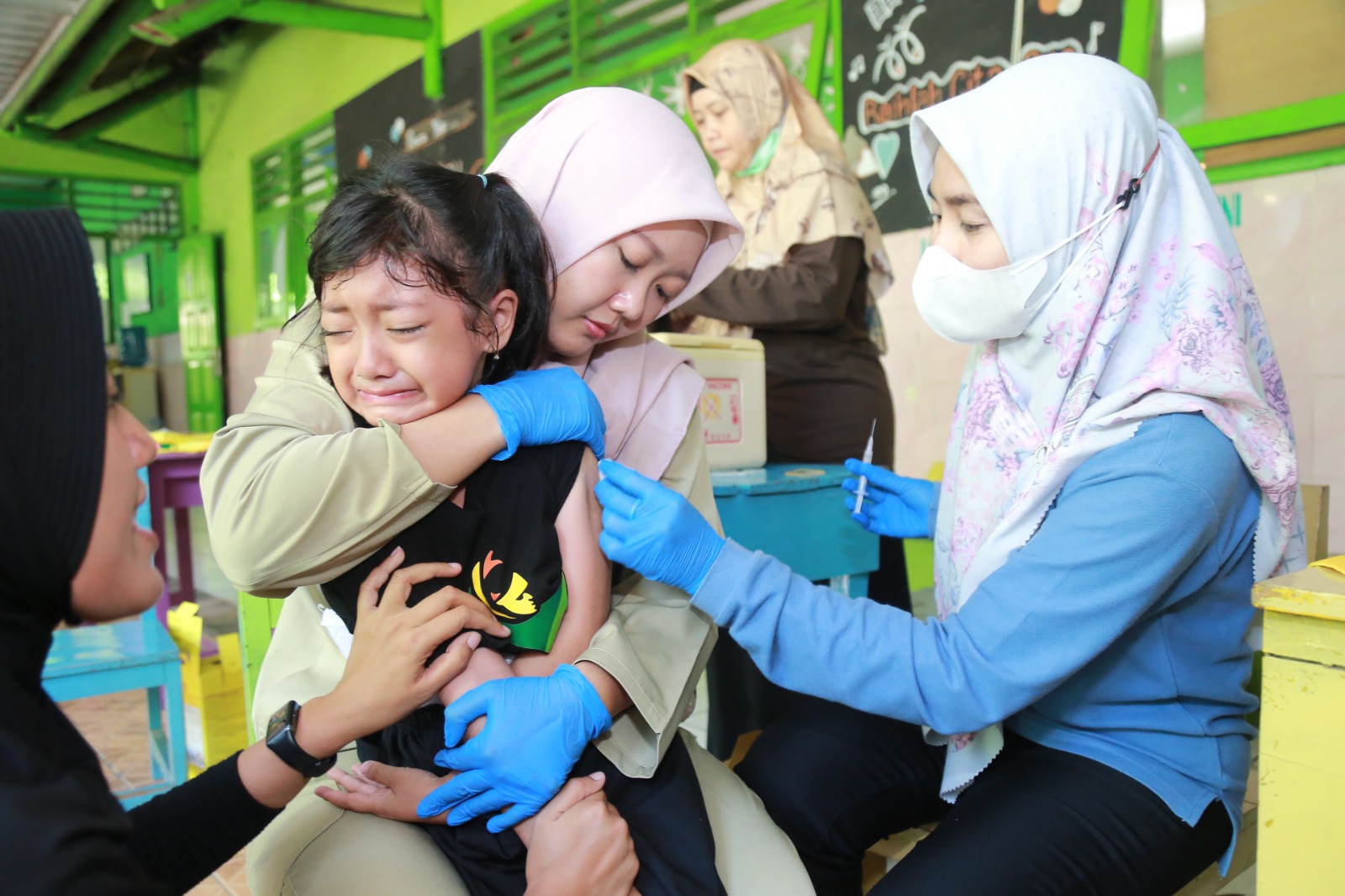 Seorang siswi SDN 02 Madiun Lor menangis saat imunisasi MR dan HPV Rabu (6/8). BAGAS BIMANTARA/RADAR MADIUN