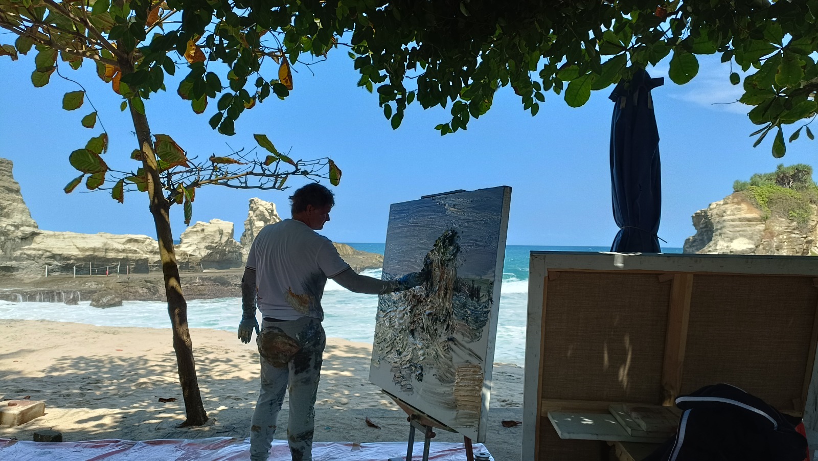 Pelukis ekspresionis asal Jerman, Christopher Lehmpfuhl, melukis Pantai Klayar dengan menggunakan teknik finger painting,&nbsp;Kamis (7/8).&nbsp;NUR CAHYONO/JAWA POS RADAR PACITAN