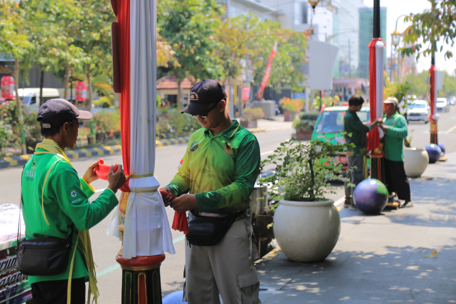 Kain merah putih dipasang di tiang PJU Jalan Pahlawan sebagai bagian dari dekorasi Agustusan. BAGAS BIMANTARA/RADAR MADIUN