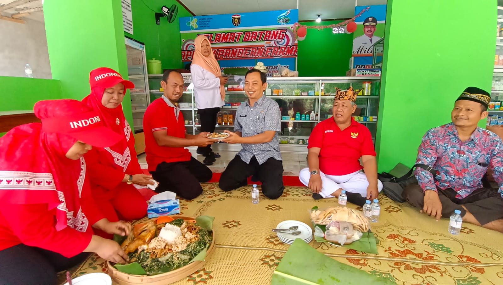TUMPENGAN: Camat Karanganyar menerima potongan tumpeng usai pembukaan Apotek Pandean Farma.