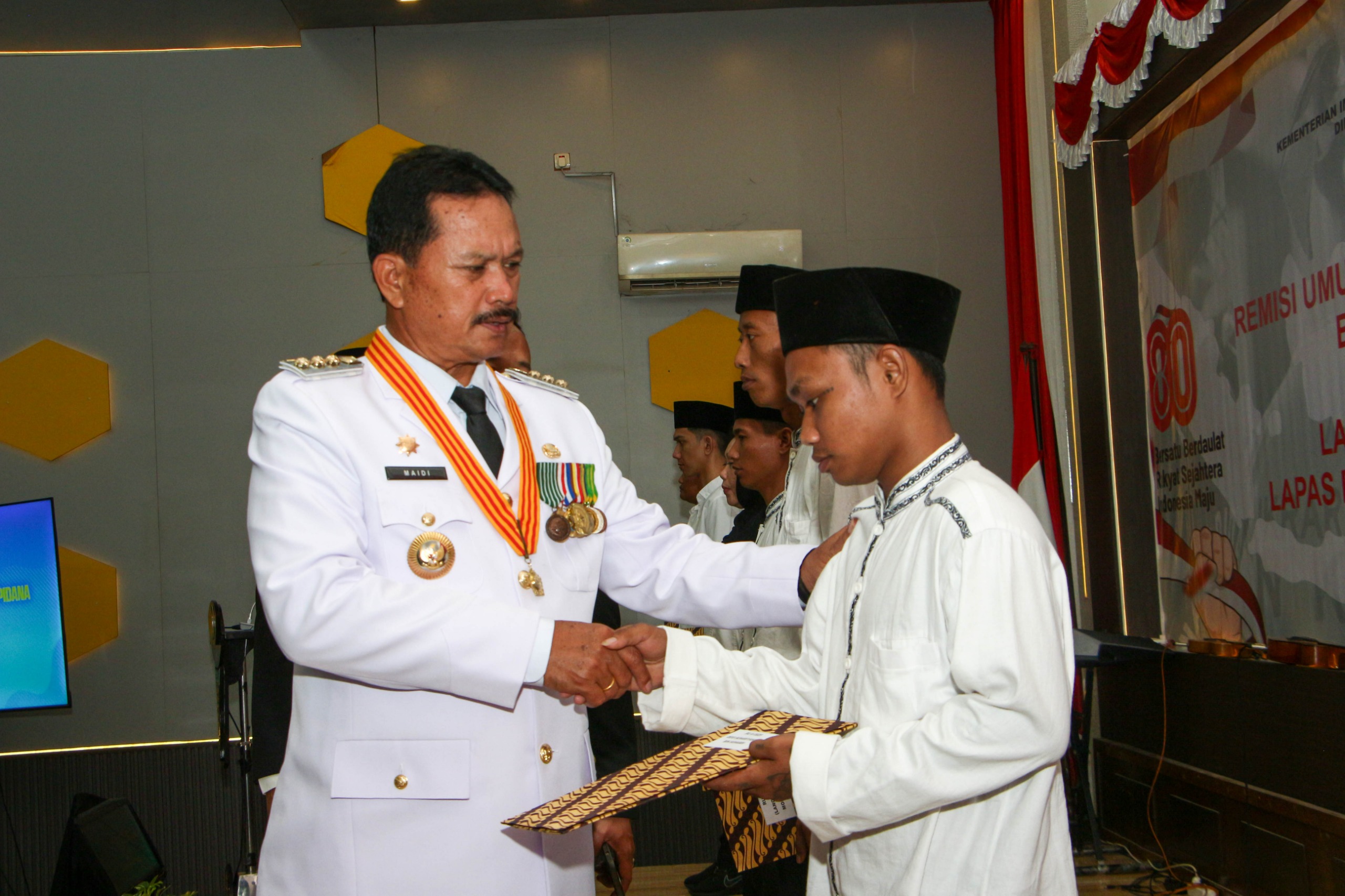 Wali Kota Madiun Maidi menyerahkan SK remisi kepada perwakilan warga binaan dalam peringatan HUT ke-80 RI di Aula Sahardjo Lapas I Madiun, Minggu (17/8). FOTO: LAPAS KELAS I MADIUN