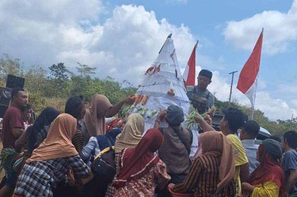 BEREBUT GUNUNGAN: Penonton berebut gunungan sayur usai karnaval.