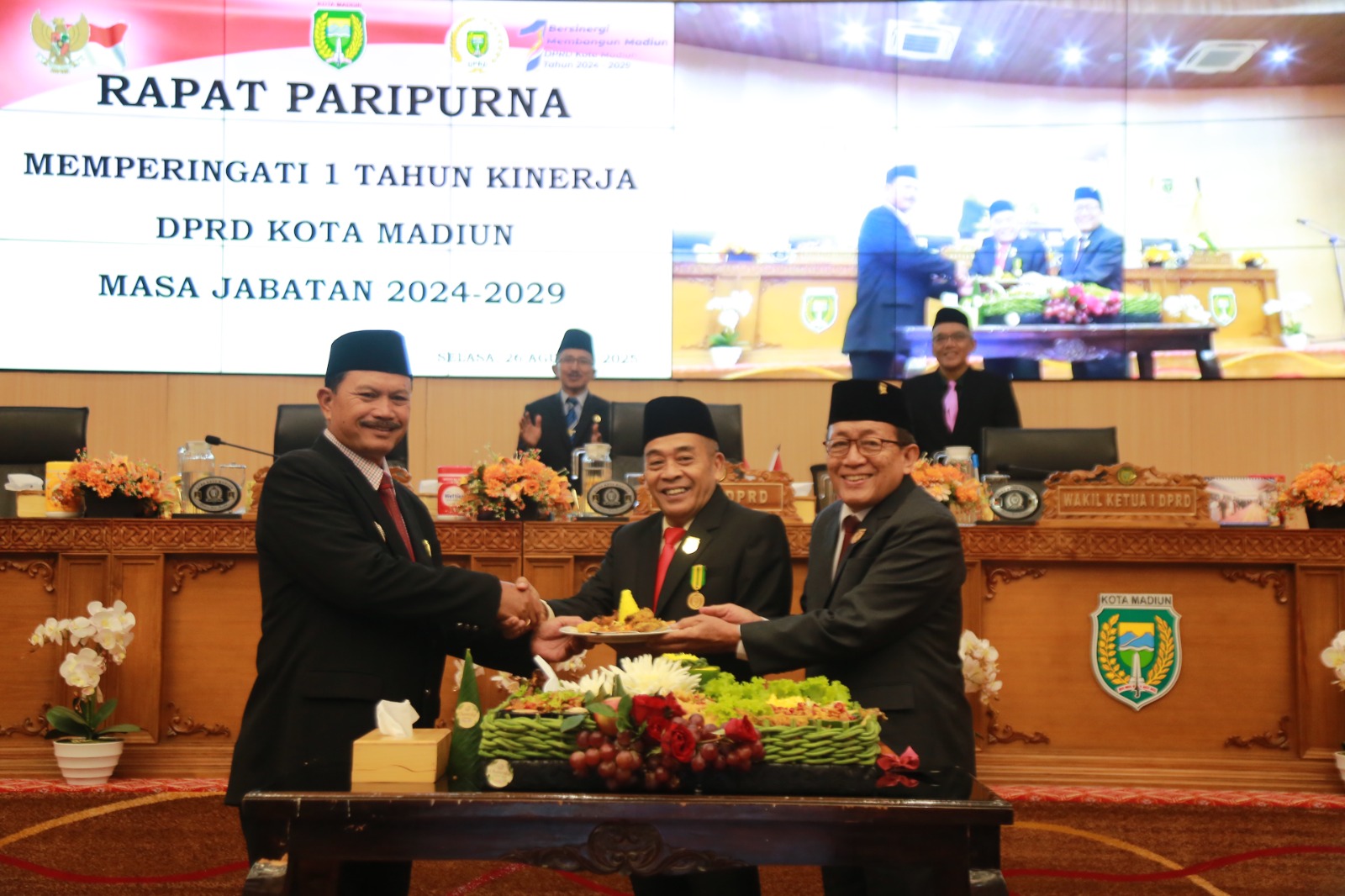 Ketua DPRD Kota Madiun Armaya bersama Wakil Ketua DPRD Sutardi memberikan potongan tumpeng kepada Wali Kota Maidi saat perayaan setahun masa jabatan anggota DPRD 2024&ndash;2029, Selasa (26/8).