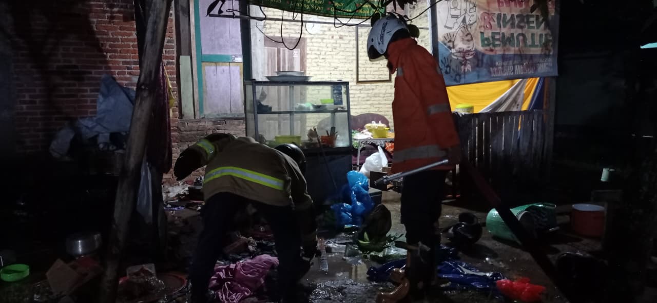 Petugas Damkar Pacitan memadamkan api akibat kebocoran gas LPG di rumah warga Lingkungan Gantung. NUR CAHYONO/RADAR PACITAN