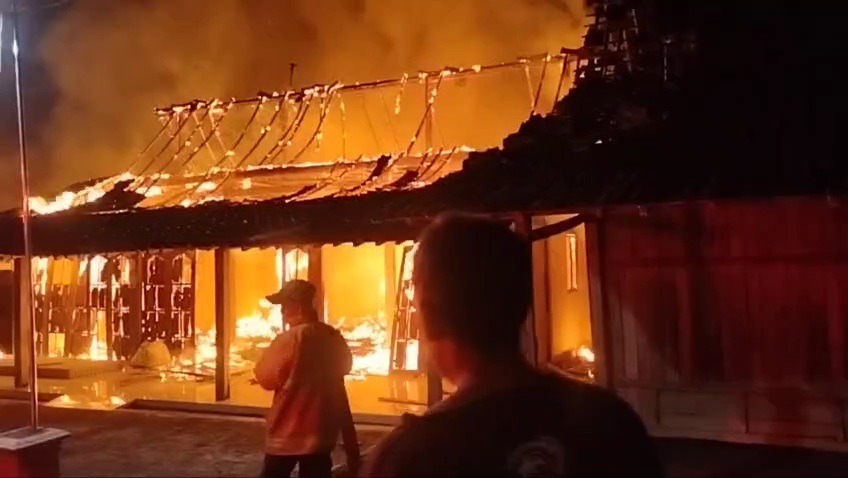 Petugas damkar Satpol PP Ngawi berjibaku memadamkan api yang membakar rumah Suparman di Desa Banyu Biru, Widodaren, kemarin. FOTO: ISTIMEWA
