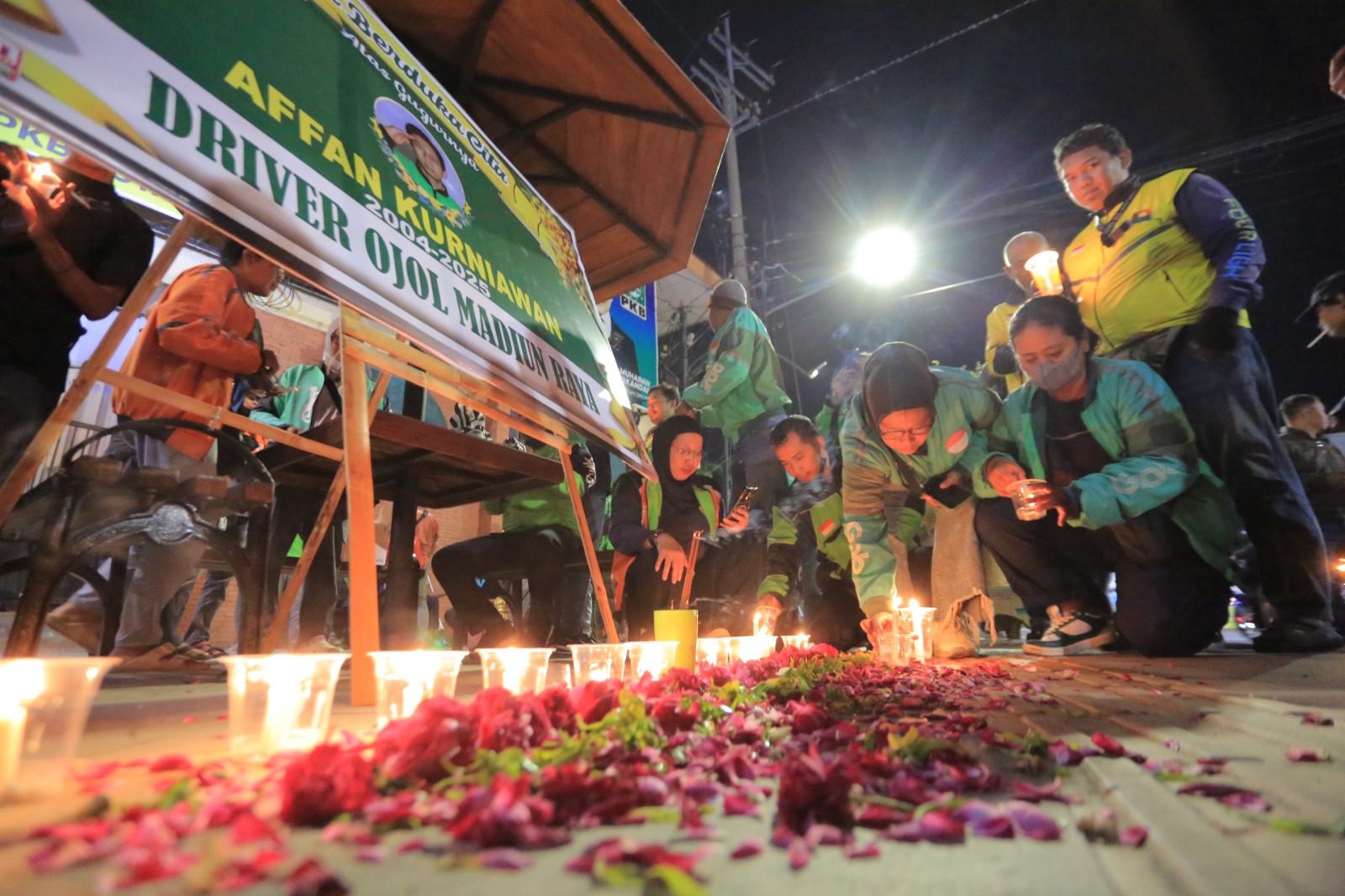 Ratusan driver ojol Madiun menyalakan lilin di Tugu Pendekar, Jumat (29/8), mengenang Affan Kurniawan yang wafat saat aksi di Jakarta. BAGAS BIMANTARA/RADAR MADIUN