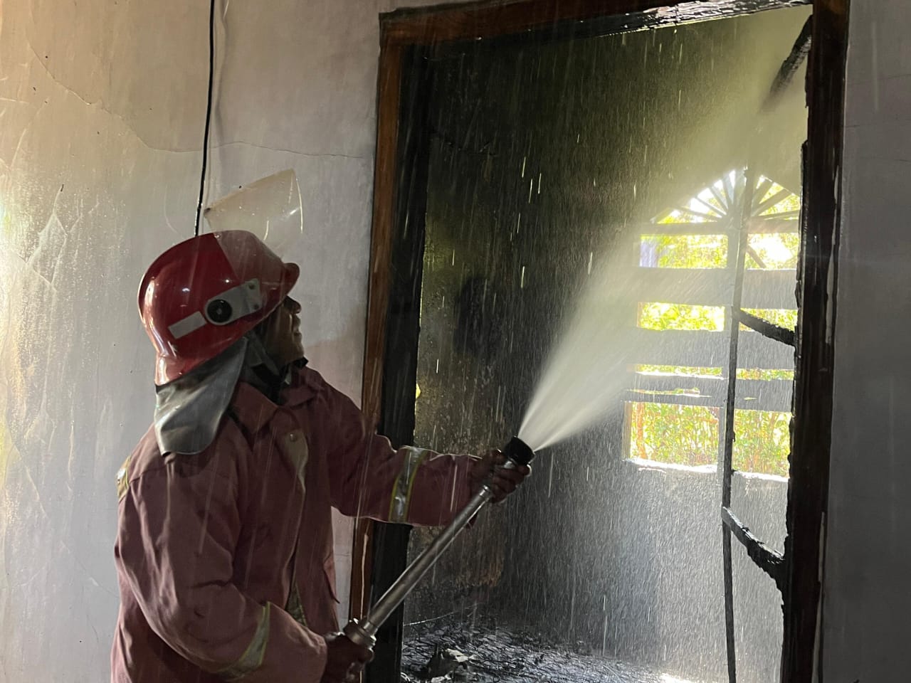 Petugas Damkar Pacitan berusaha memadamkan api yang membakar kamar rumah warga Donorojo, Selasa (2/9) pagi. FOTO: ISTIMEWA