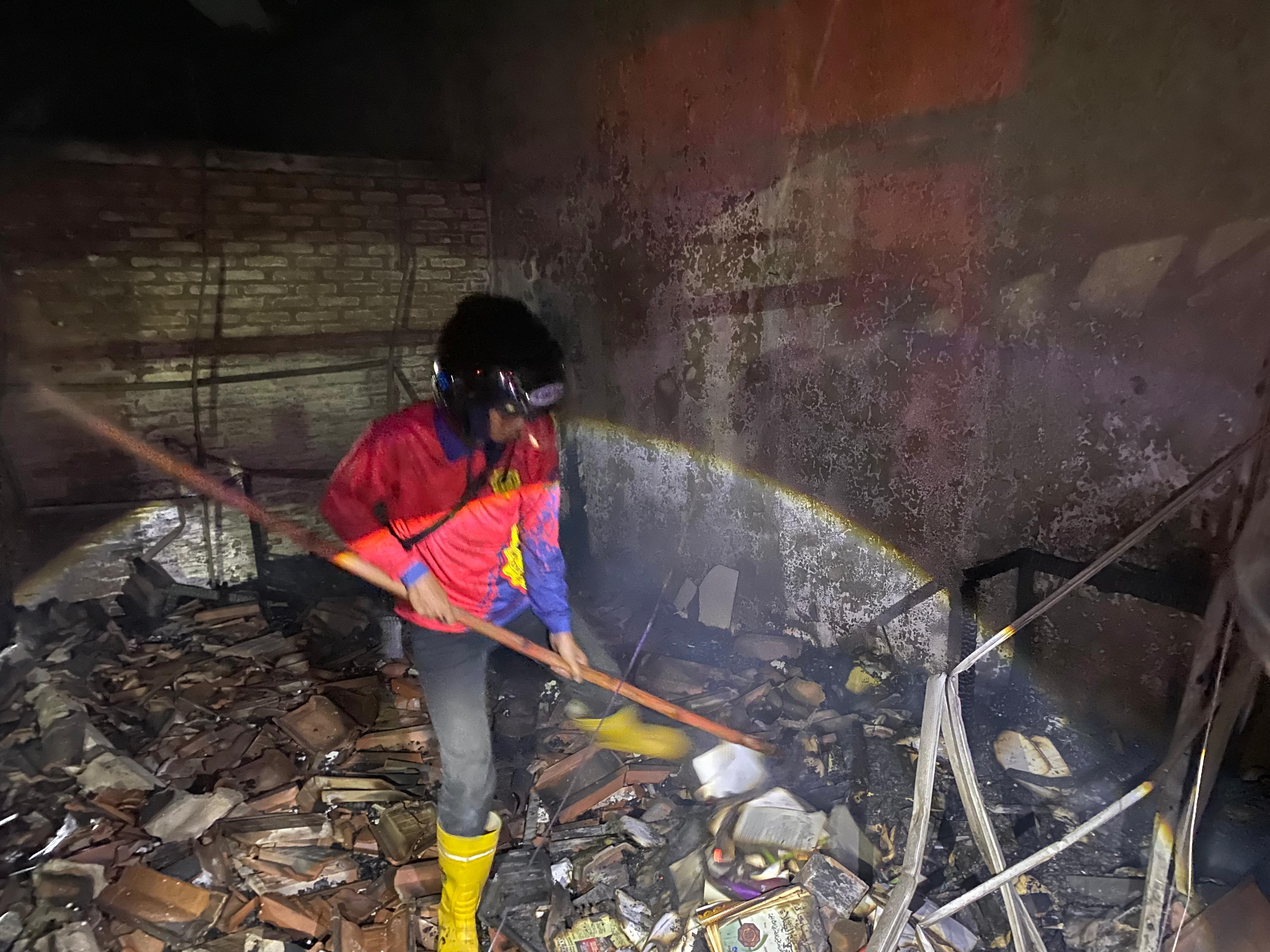 Petugas damkar berupaya memadamkan api yang membakar rumah milik Suyanto di Gang Masjid Gading, Manguharjo, Sabtu (13/9). ERLITA H/RADAR MADIUN