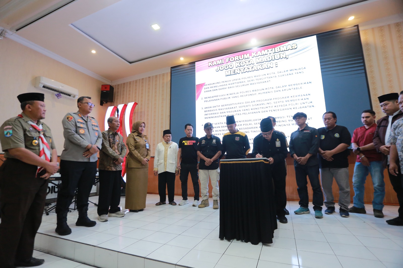 Kapolres Madiun Kota AKBP Wiwin Junianto Supriyadi bersama tokoh masyarakat, tokoh agama, dan pemuda menandatangani ikrar menjaga kondusivitas Kota Madiun di Mapolresta, Selasa (16/9). BAGAS BIMANTARA