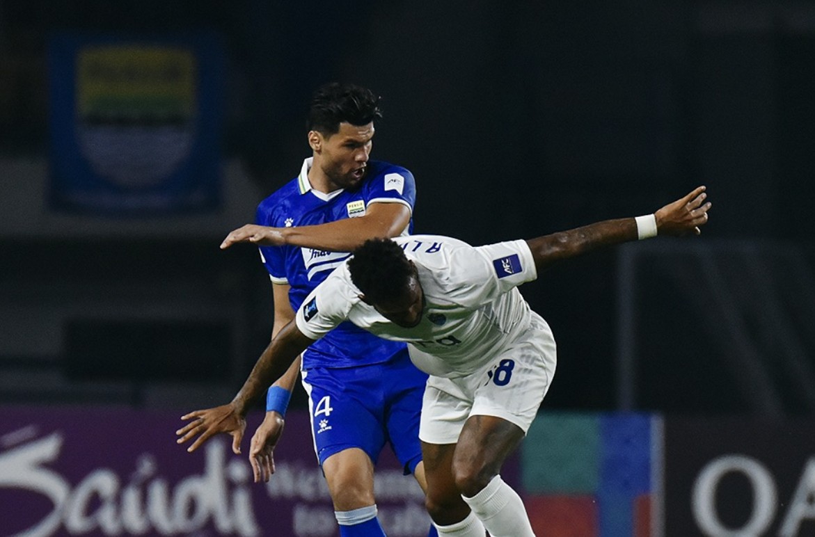 Bek Persib Bandung Julio Cesar berduel dengan lawan.