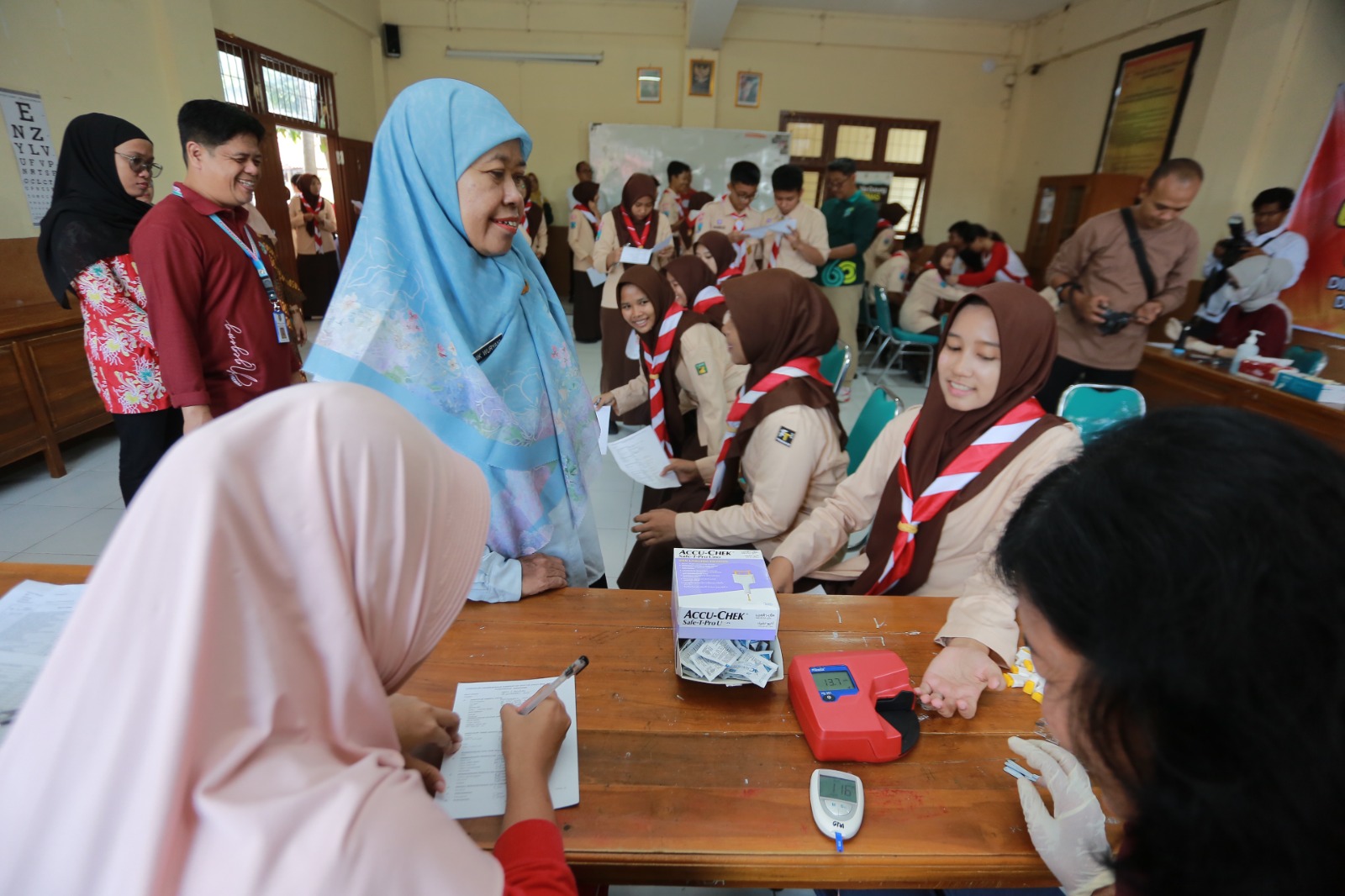 Petugas Dinkes-PPKB memeriksa kesehatan siswa SMA Negeri 2 Madiun dalam program cek kesehatan gratis (CKG), kemarin (19/9). BAGAS BIMANTARA/RADAR MADIUN
