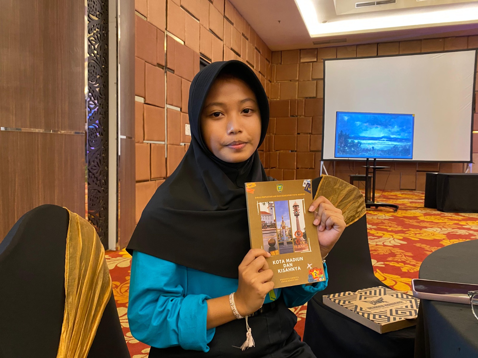 INSPIRATIF: Naila Aprillya Padila menunjukkan cerpen karyanya yang masuk dalam buku Kota Madiun dan kisahnya.