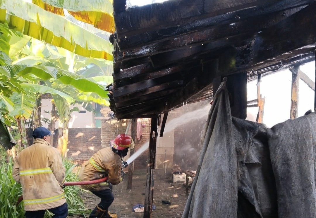 Petugas damkar berupaya memadamkan api yang melalap rumah Painem, warga Desa Keniten, Geneng, hingga rata dengan tanah. ASEP SYAEFUL/RADAR NGAWI