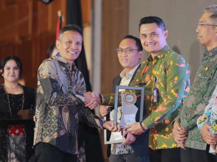 Kepala Dispendukcapil Kota Madiun Agus Triono menerima penghargaan Radar Madiun Awards 2025.