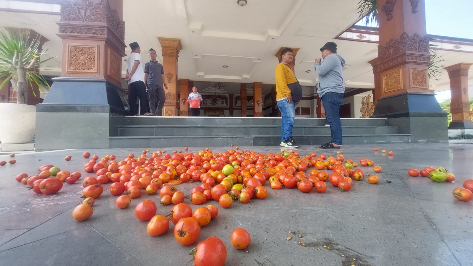 Para petani tomat dari Kare membuang hasil panen mereka di halaman Pendapa Pemkab Madiun kemarin (3/10).