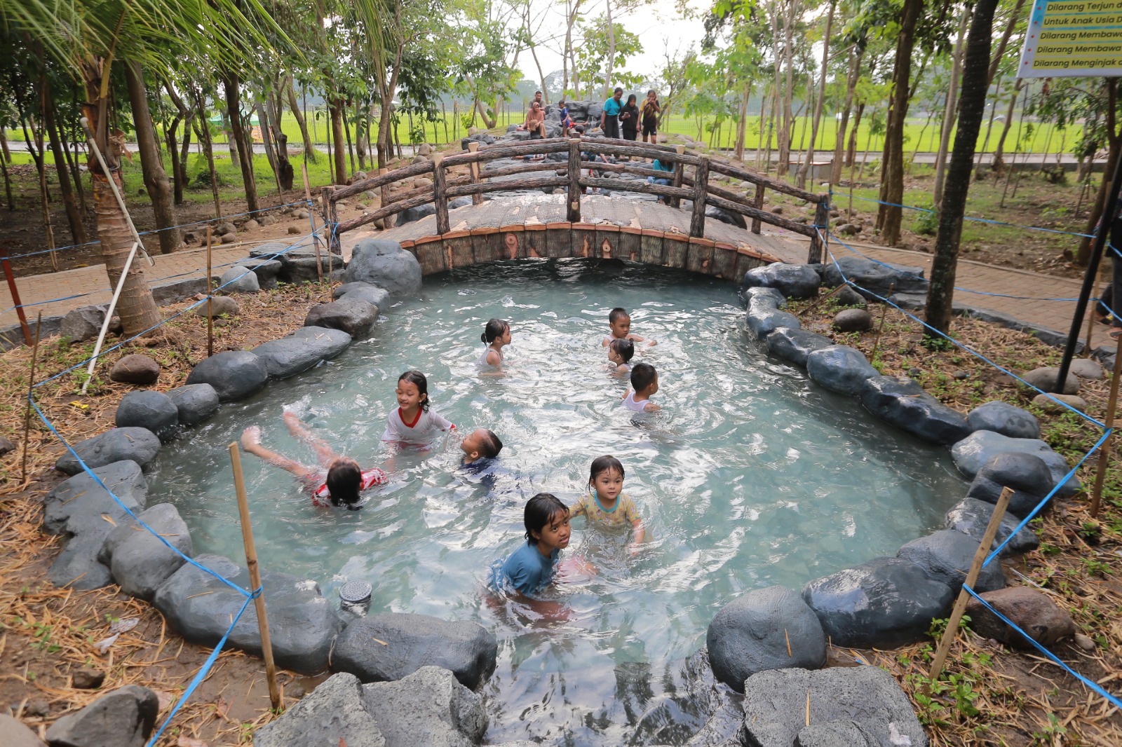 Anak-anak menikmati sejuknya suasana sambil bermain air di kolam Taman Hutan Kota Madiun, Jalan Basuki Rahmat. BAGAS BIMANTARA/RADAR MADIUN