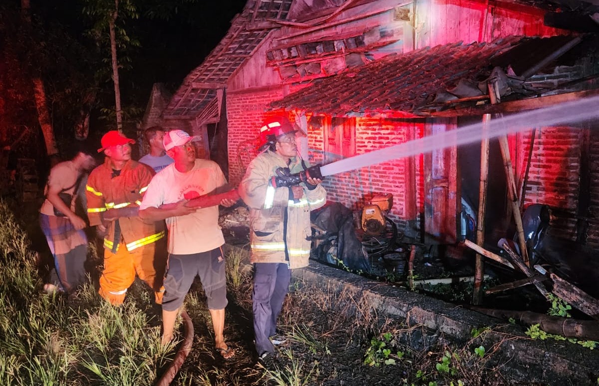 Petugas Damkar Ngawi berusaha memadamkan api yang membakar rumah Sumiyem, 75, di Desa Tempuran, Paron, Selasa malam (14/10).