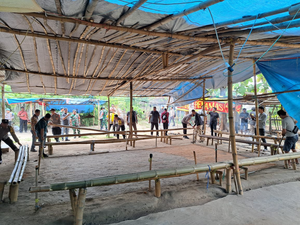 Petugas Polsek Bendo bersama unsur TNI membongkar fasilitas arena sabung ayam di Desa Setren, Kecamatan Bendo, Kamis (16/10). POLRES UNTUK RADAR MAGETAN