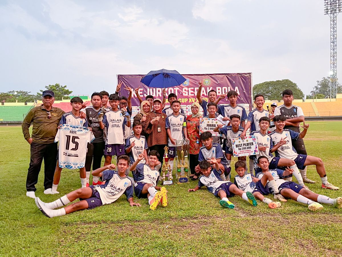 CHAMPIONS: Kadindik Kota Madiun Lismawati dan Kepala SMPN 13 Anik Suyatni menyerahkan penghargaan kepada tim Galas yang menjuarai Kejurkot Sepak Bola Galas Cup XV.