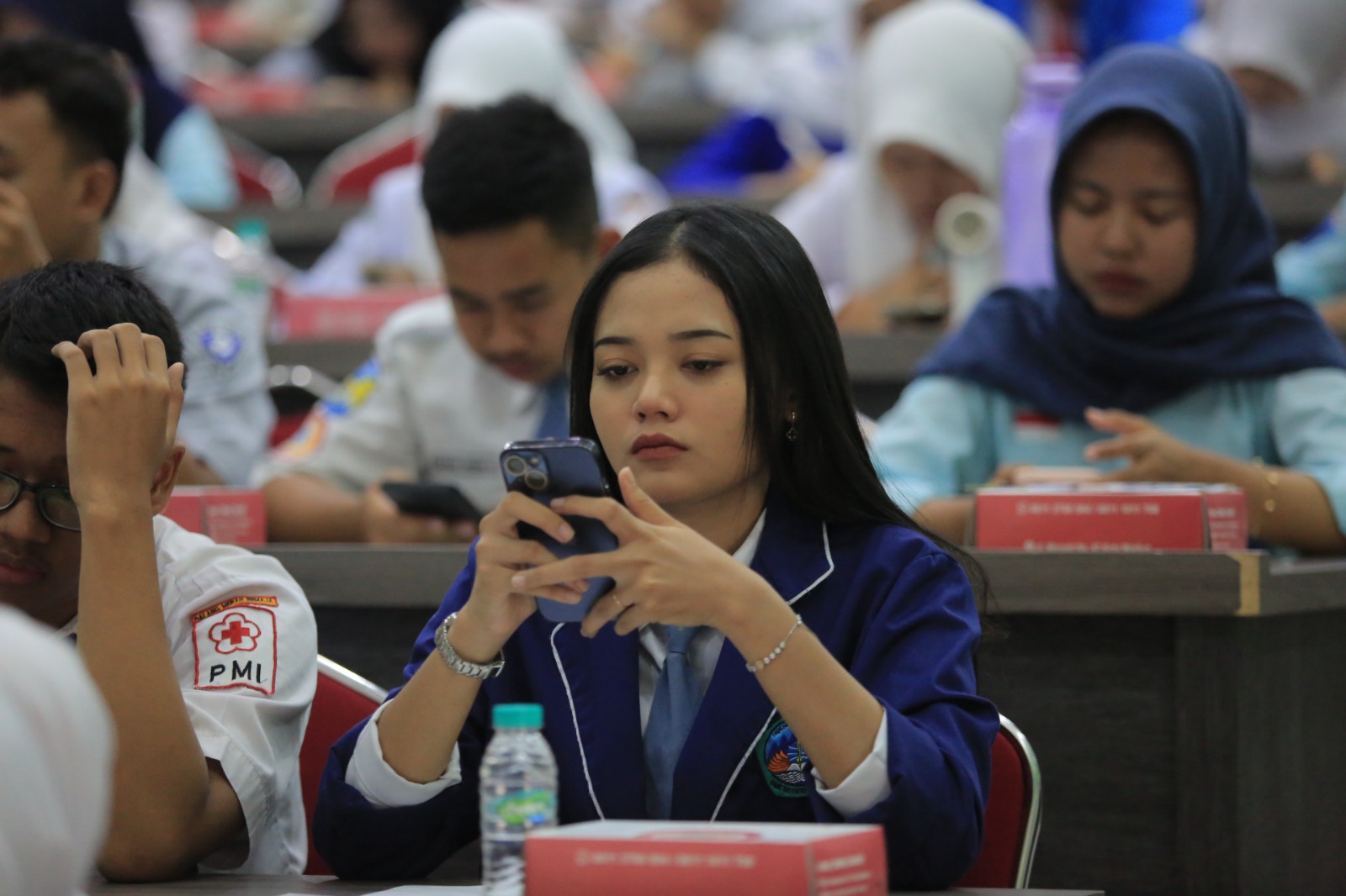 Seorang siswi sedang mengerjakan soal TKA Challenge 2025 dengan menggunakan telepon genggam. BAGAS BIMANTARA/RADAR MADIUN