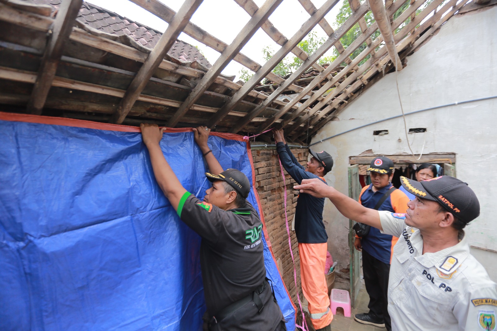 Petugas BPBD Kota Madiun membersihkan reruntuhan rumah warga di Ngegong yang rusak usai diterjang angin kencang, Sabtu (18/10). BAGAS BIMANTARA/JAWA POS RADAR MADIUN