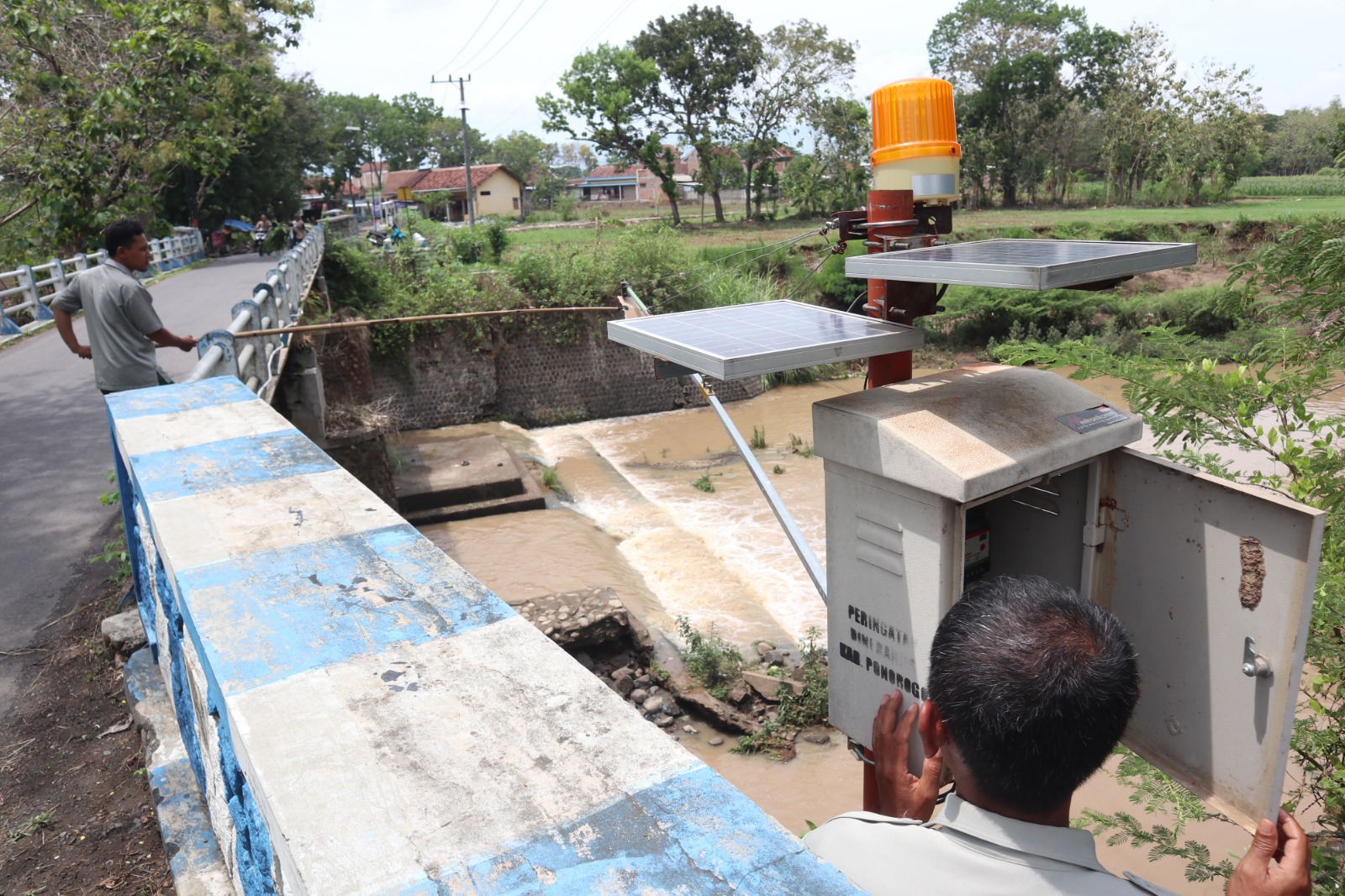 Petugas BPBD Ponorogo memeriksa alat EWS banjir di Sungai Tempuran. Perawatan dilakukan agar alarm bencana berfungsi maksimal saat penghujan. SUGENG DWI N/RADAR PONOROGO