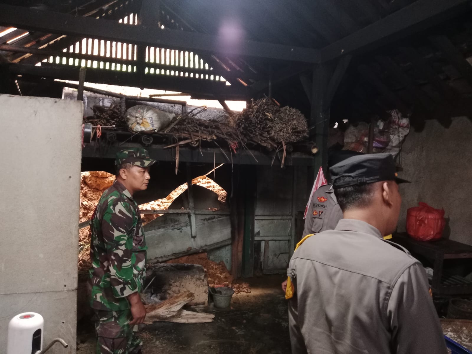 Petugas meninjau rumah warga di Nawangan, Pacitan, yang rusak tertimpa longsor, Jumat (24/10). Lima rumah dilaporkan terdampak.